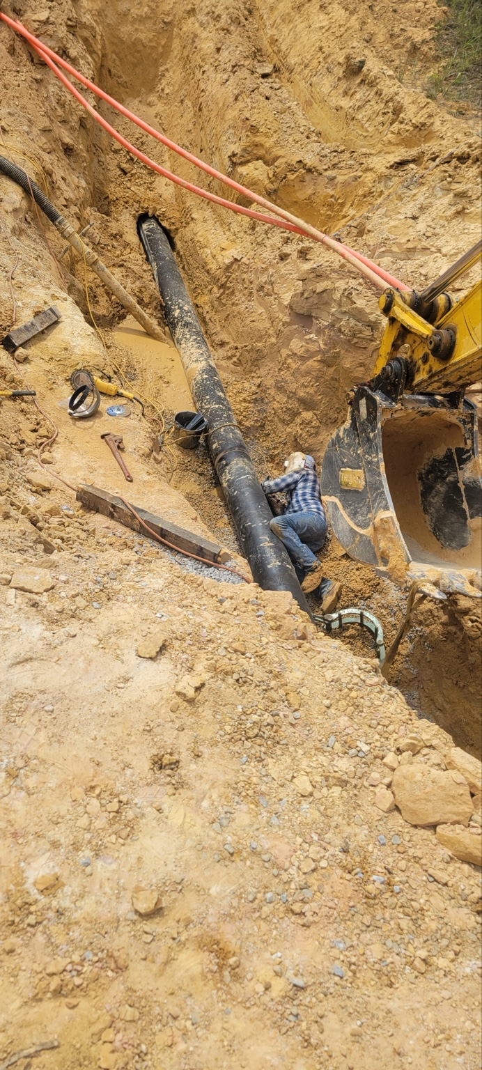Water main work within the excavated utility trench.